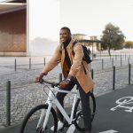 Jeune actif posant fièrement à vélo sur une piste cyclable