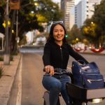 Femme souriante à vélo en ville en soirée
