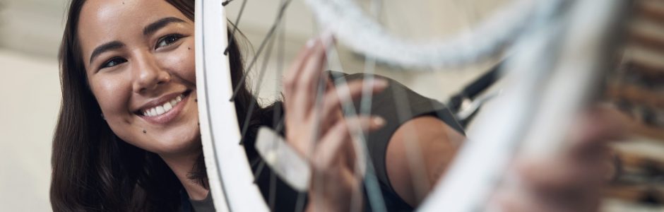 Jeune femme réparant son vélo en boutique
